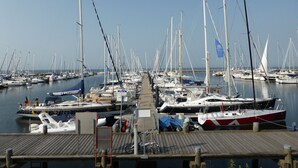 Eine Marina mit zahlreichen Segelbooten, die in ruhigem Wasser liegen.