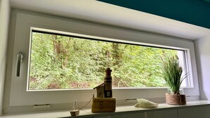 Ein Fenster mit Blick auf einen Wald.
