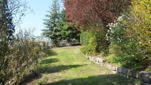 A pathway through a garden with various shrubs and trees. - kunstsammler by Interhome (Dresden)