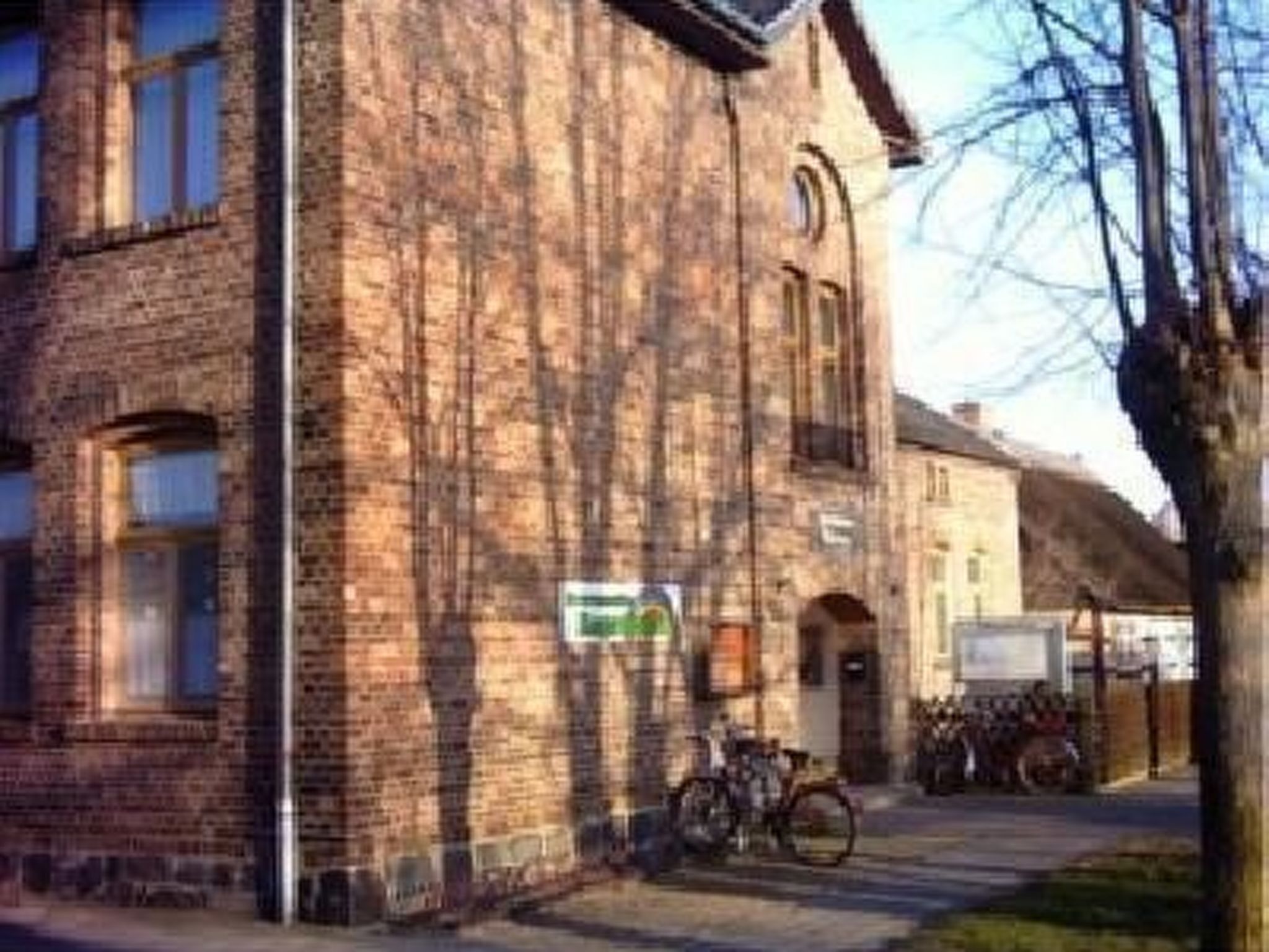 Un bâtiment en briques sur lequel est apposée une enseigne indiquant un commerce ou un service.