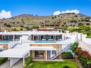 A modern two-story villa with a swimming pool, stone facade, and a view of a mountainous landscape. - Villa Kleovoulini by Interhome (Pefki)