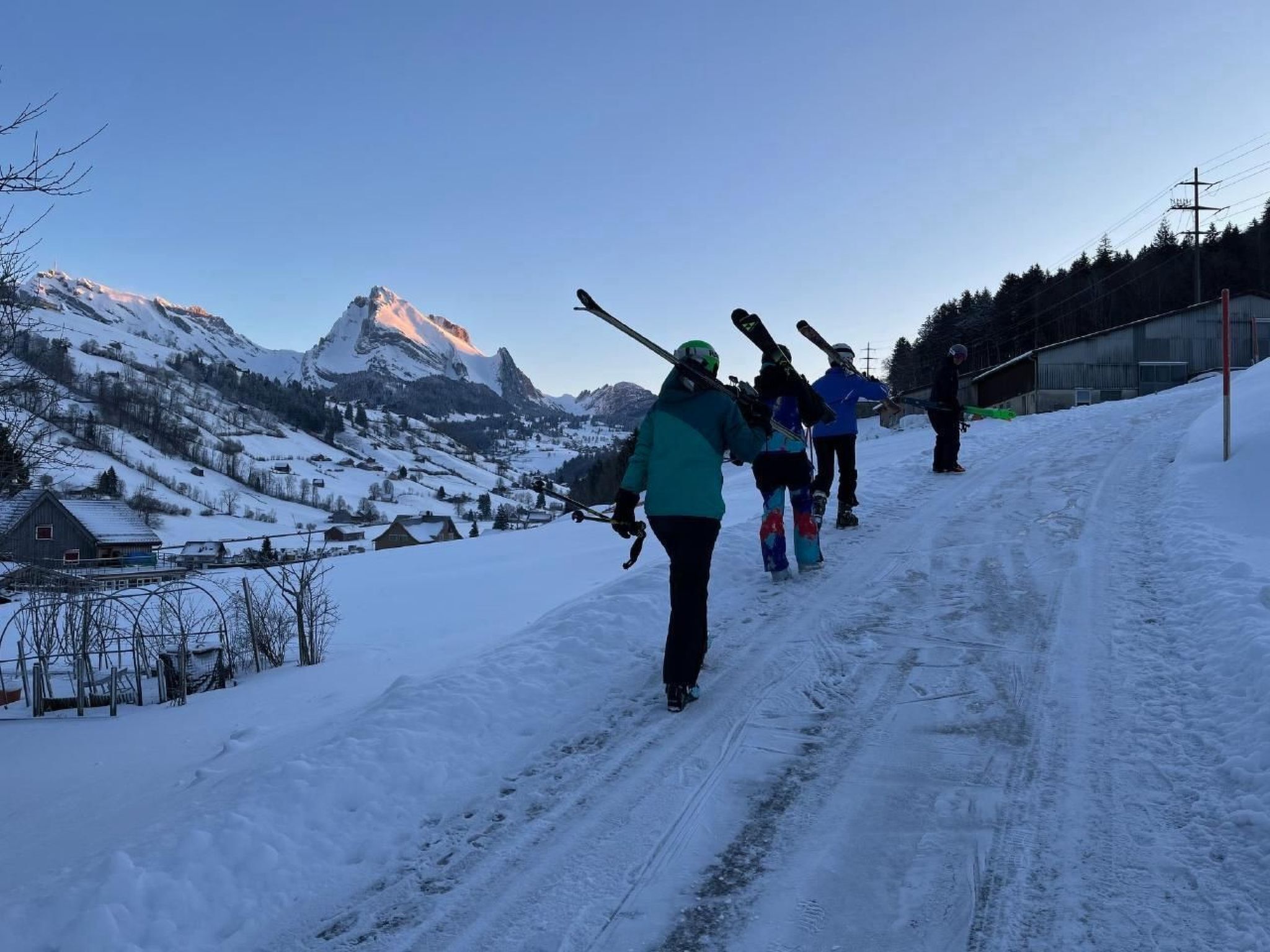 Un groupe de personnes fait du ski sur une piste enneigée, avec une montagne en arrière-plan.