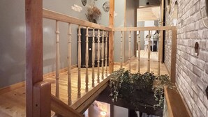 Una escalera de madera con barandilla que baja a un nivel inferior.