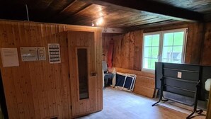 Ein Zimmer mit Holzwänden, einem Fenster mit Aussicht, einer Tür und einer Bank.