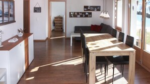 Una cocina moderna con una mesa y sillas de madera, horno empotrado y un armario blanco.