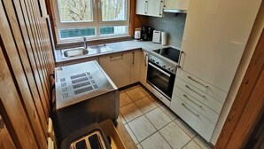 A compact kitchen with a sink, stove, and cabinets. - Vacation home Merle by Interhome (Extertal)