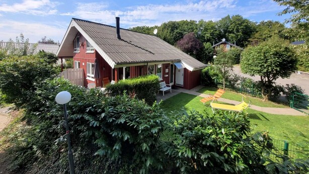 A red house with a sloped roof and a small porch. - Vacation home Merle by Interhome (Extertal)