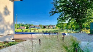 Ein Wohngebiet mit Schwimmbad, einem gepflasterten Weg und einer Rasenfläche mit hohem Gras.