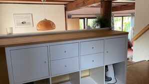 A modern kitchen with white cabinetry, a wooden countertop, and a hanging pendant light. - Lisa am Silbersee  Silberseeblick by Interhome (Frielendorf)