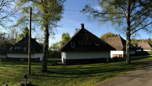 A row of traditional houses with sloped roofs, surrounded by well-maintained lawns and trees. - Idyllisches Ferienhaus mit Balkon und Garten by Interhome (Frielendorf)