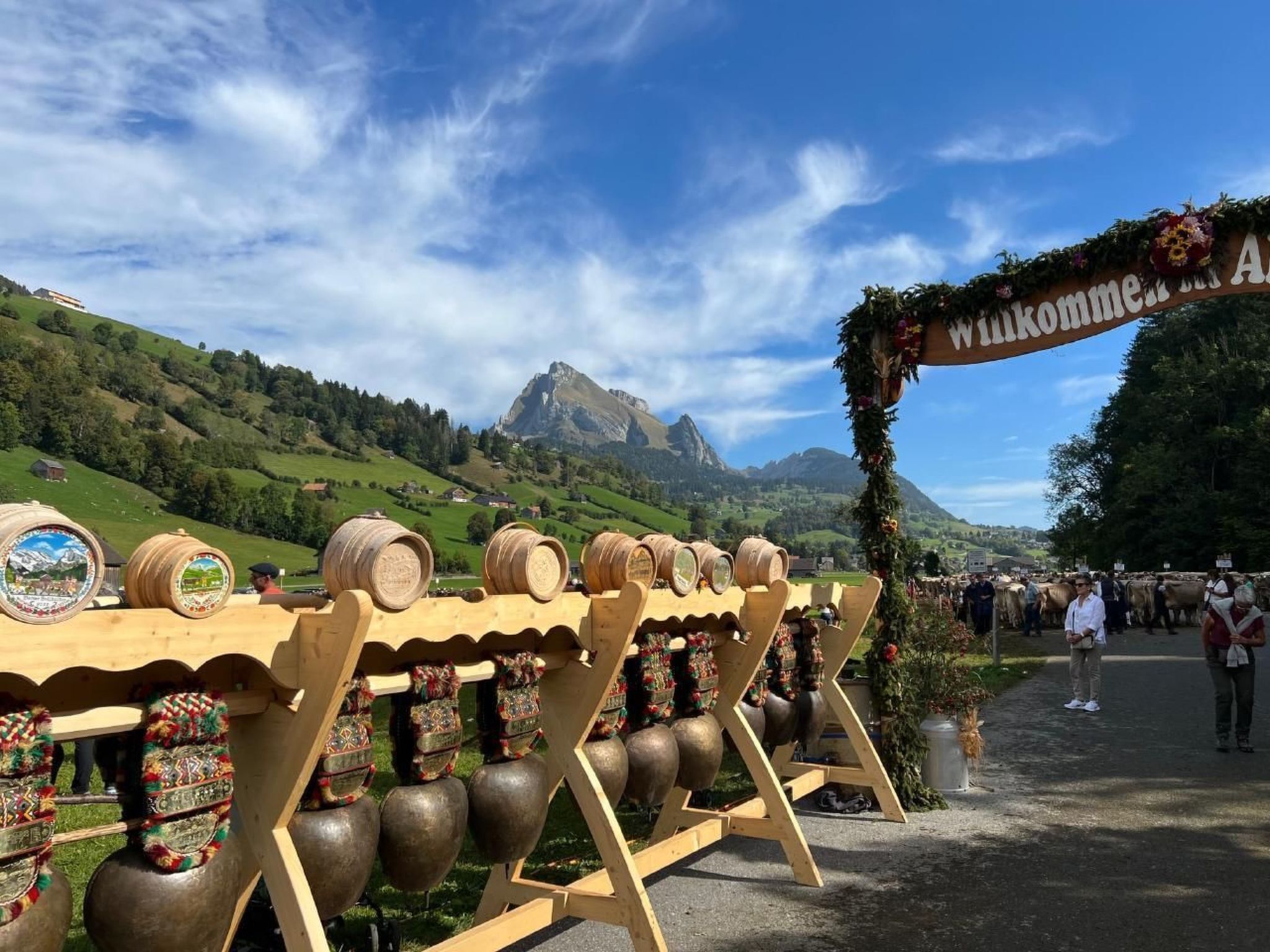 Een houten constructie met vaten en decoratieve elementen, op de achtergrond een berglandschap met heldere lucht.