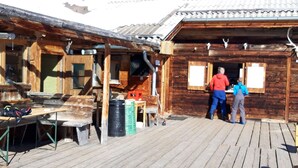 Eine Holzhütte mit einer Holzterrasse, einem Tisch und Stühlen.