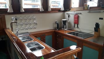 Een koelkast, een magnetron, een oven, kookgerei, borden en bestek