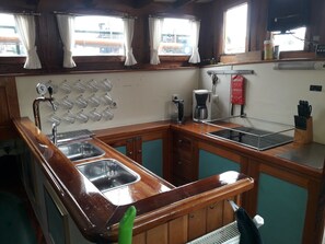 Een koelkast, een magnetron, een oven, kookgerei, borden en bestek