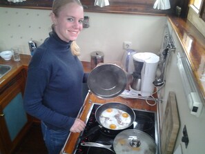 Een koelkast, een magnetron, een oven, kookgerei, borden en bestek