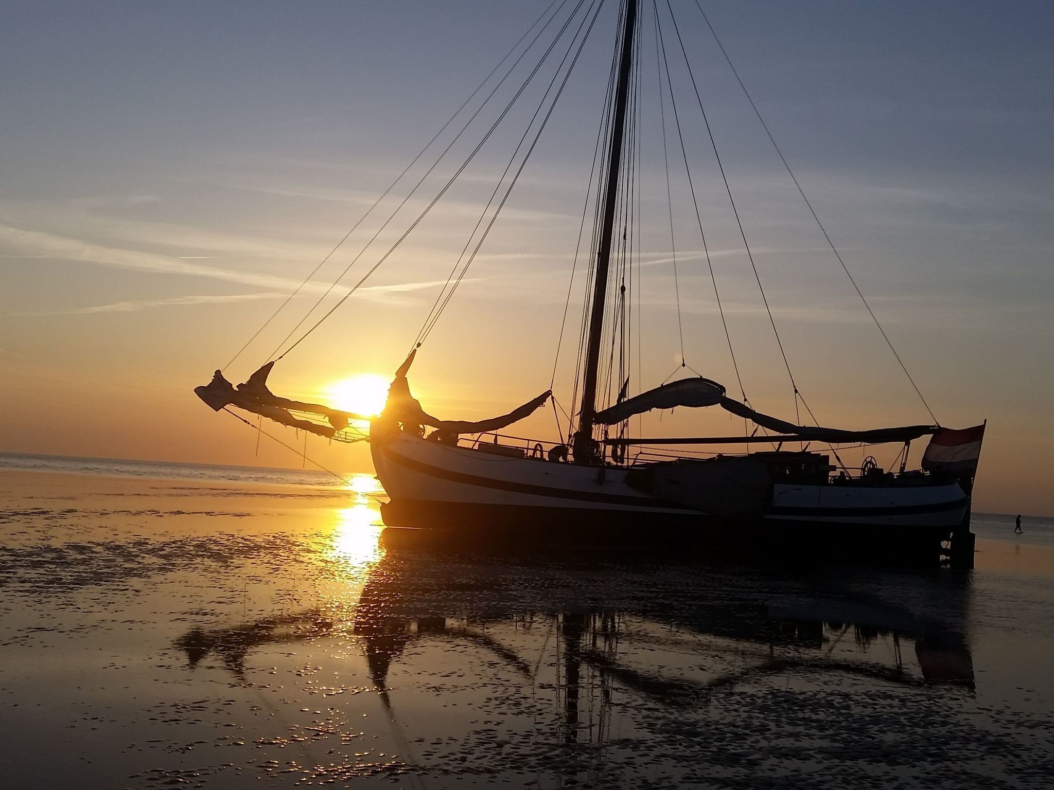 Um barco ancorado na praia ao pôr do sol.