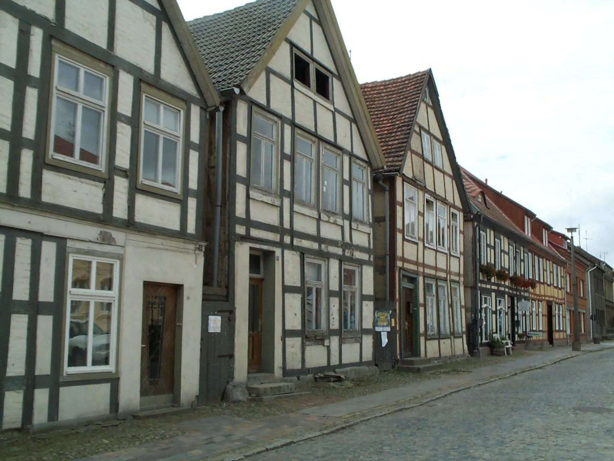 A row of traditional half-timbered buildings with a cobblestone street.