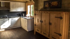 A kitchen with wooden cabinets, a stove, and a window. - Relax Chalet by Interhome (Sint-Annaland)