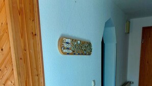 Puinen seinä, jossa on kiinnitettynä laatta, patteri ja puuportaat.