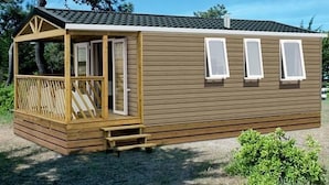 A small, single-story cabin with a wooden deck, a covered porch, and three windows. - in Hohenlychen mit Grill, Loggia 3 by Interhome (Lychen)