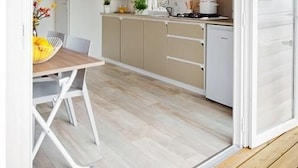 A compact kitchen with a dining area, a microwave, and a sink. - in Hohenlychen mit Grill, Loggia 3 by Interhome (Lychen)