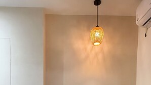 Una sala de estar moderna con un sofá, una mesita redonda y una lámpara colgante.
