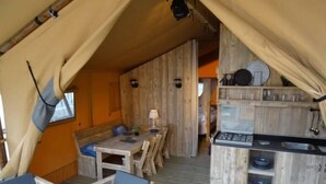 Tunnelmallinen, maalaishenkinen sisustus, jossa on ruokailutila, pieni keittiö ja oleskelualue.