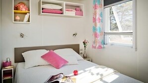 A neatly arranged bedroom with a bed, bedside tables, and a window with a view. - in Hohenlychen mit Grill, Loggia 1 by Interhome (Lychen)