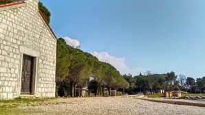 A stone building with a red-tiled roof, a chimney, and a door. - Appartement in Đuba mit Privater Terrasse by Interhome (Umag/Juricani)