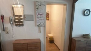 A hallway with wooden cabinets, a wall-mounted telephone, and a decorative sign. - Sonnenbichl Wh 102 by Interhome (Oberstdorf)