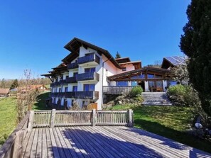 A multi-story building with balconies, a wooden deck, and a clear sky. - Wohnung in Traumlage bei Sankt Englmar by Interhome (Sankt Englmar)