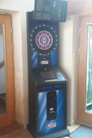 A dartboard mounted on a wall with a dartboard below it. - Wohnung in Traumlage bei Sankt Englmar by Interhome (Sankt Englmar)