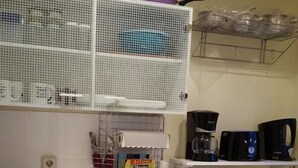 Pieni, käytännöllinen keittiö, jossa on mikroaaltouuni, kahvinkeitin ja pesuallas.