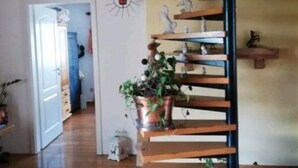 Eine Wendeltreppe mit Holzboden und einem Kupfertopf auf dem Podest.