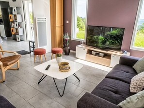 A modern living room with a sofa, a coffee table, a TV, and a bookshelf. - Ein gemütlicher Kokon im Süden der Ardèche by Interhome (Largentière)