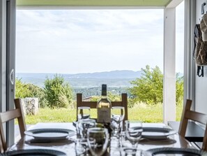 A dining table set for two with a view of a mountainous landscape. - Ein gemütlicher Kokon im Süden der Ardèche by Interhome (Largentière)