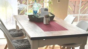 Een eettafel met stoelen, een placemat en een waterfles erop.