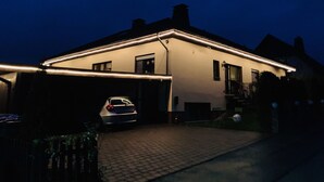 Uma casa com garagem, entrada para carros e um carro estacionado dentro.