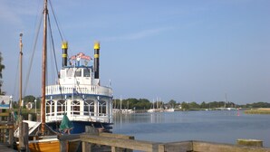 Un muelle junto al río con un barco grande llamado "Hurricane" amarrado.