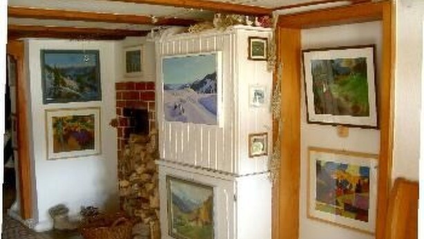 Una habitación con chimenea, cuadros en las paredes y una pared de piedra.