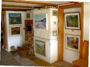 Ein Zimmer mit Kamin, gerahmten Bildern an den Wänden und einer Steinwand.