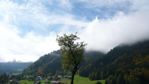 A rural landscape with a single tree in the foreground, a village in the midground, and a mountain range in the background. - Falkenberg Wh 218 by Interhome (Oberstdorf)