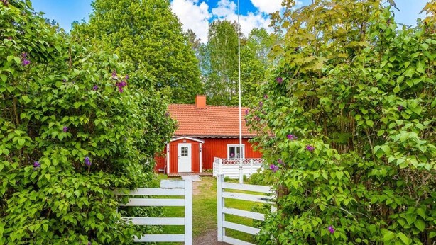 A red house with a white door and a white fence in front. - Vacation home Ida by Interhome (Mariannelund)