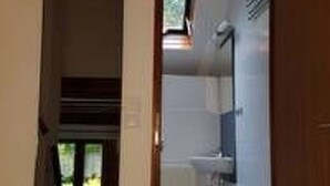 A narrow hallway leading to a bathroom with a window and a door. - Vacation home Tindy by Interhome (Frielendorf)