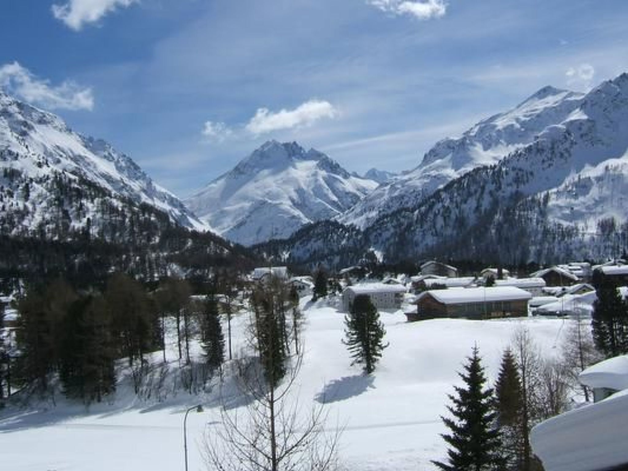 Un paysage montagneux enneigé avec un petit village.