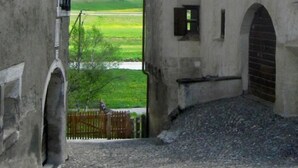 A rustic building with a stone facade and a small arched entrance. - Chesa Robbi S-chanf by Interhome (S-chanf)