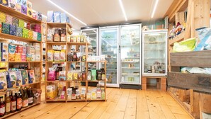 Ein Geschäft mit Holzboden, Regalen voller verschiedener Lebensmittel und einem Kühlschrank.