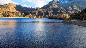 Un lac paisible, entouré de montagnes et d’arbres.