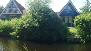 Un hilera de casas con un cuerpo de agua al frente.