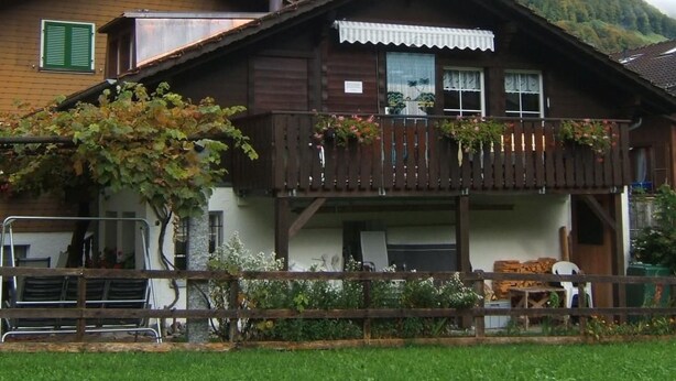 A traditional wooden chalet with a balcony, surrounded by lush greenery and a mountainous backdrop. - Chalet Imfeld-Gander by Interhome (Bürglen OW)